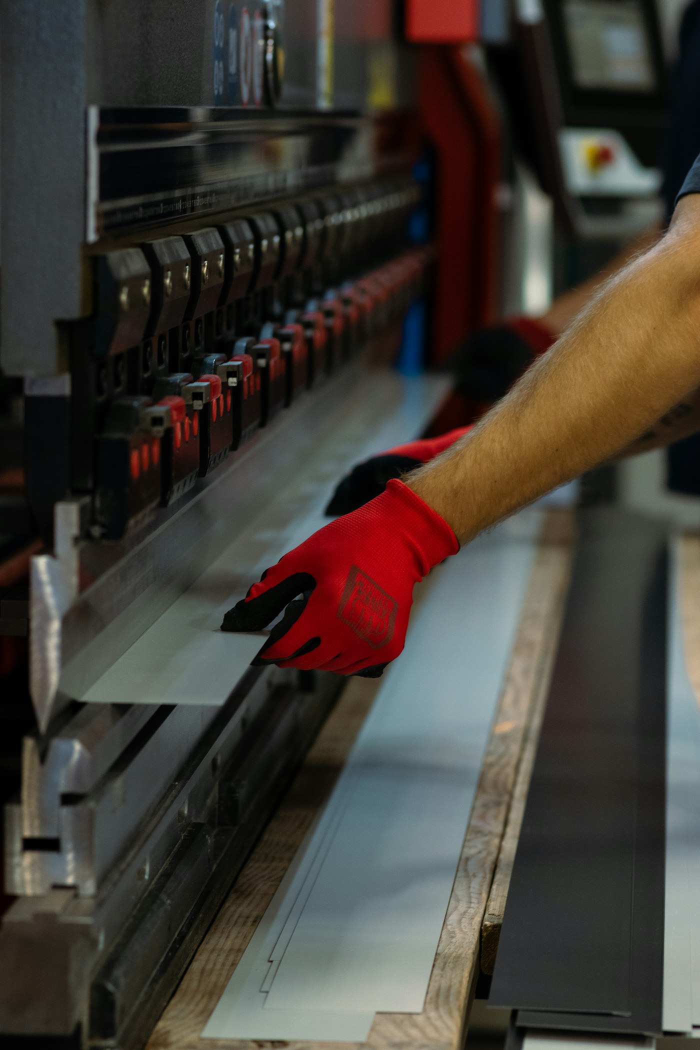 Operator handling sheet metal at the press brake
